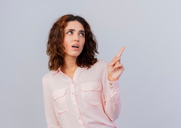 Unpleased young caucasian woman looks and points at side