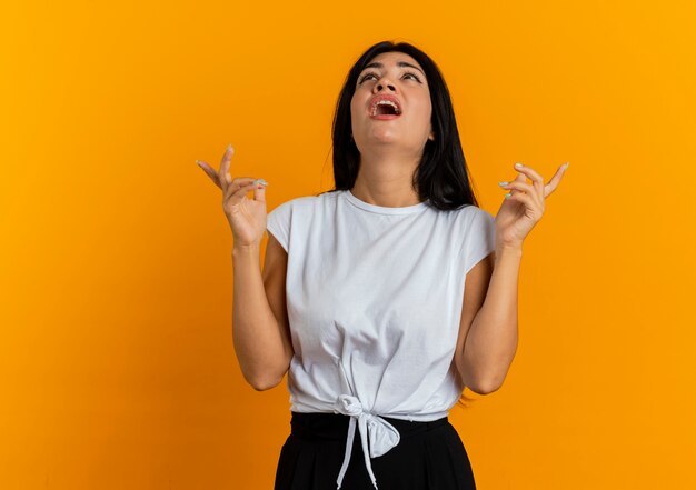 Unpleased young caucasian woman looks and points up with two hands