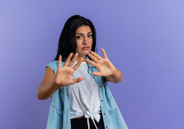 Unpleased young caucasian woman stretching out hands gesturing no