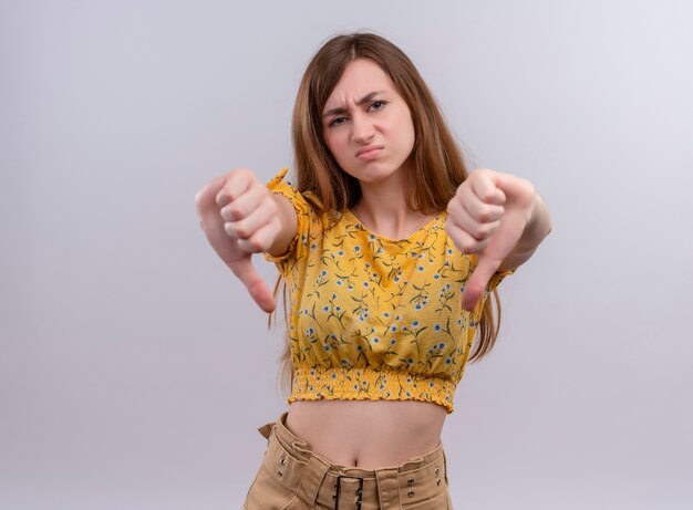 Unpleased young girl showing thumbs down on isolated white wall with copy space