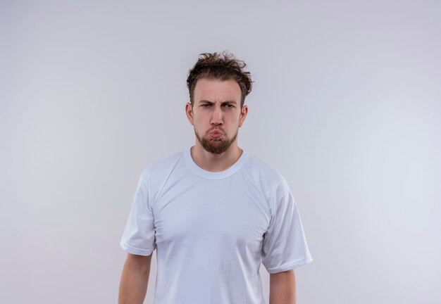 Unpleased young guy wearing white t-shirt on isolated white wall