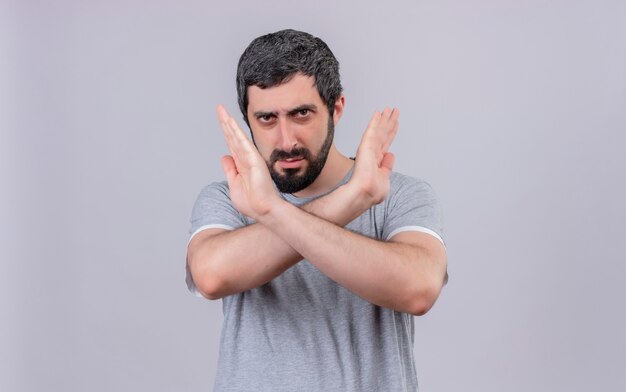 Unpleased young handsome caucasian man gesturing no at camera isolated on white background with copy space