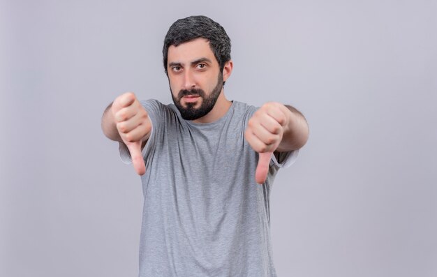 Unpleased young handsome caucasian man showing thumbs down isolated on white background with copy space