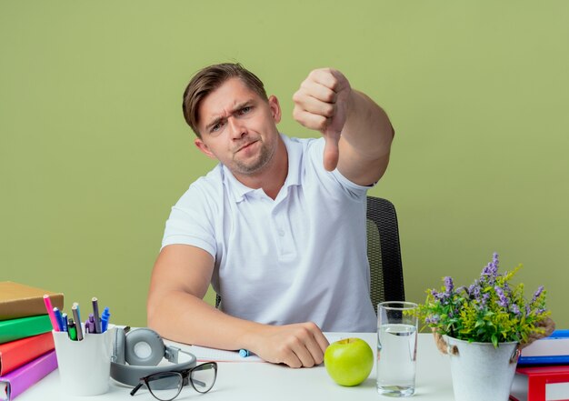 책상에 앉아 unpleased 젊은 잘 생긴 남자 학생