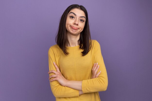 unpleased young pretty caucasian girl standing with closed posture  isolated on purple wall with copy space