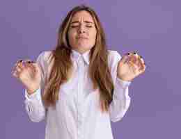 Free photo unpleased young pretty caucasian girl stands with raised hands on purple