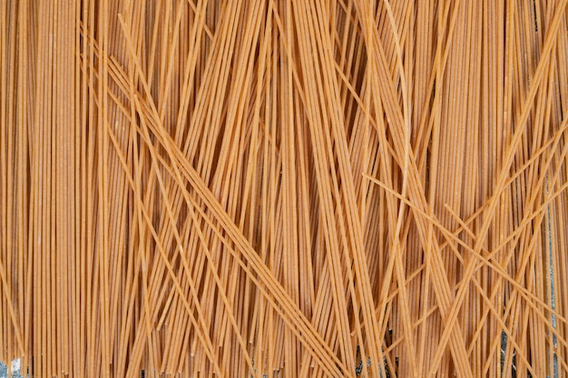 Неподготовленные макаронные изделия из цельнозерновых спагетти на мраморном пространстве