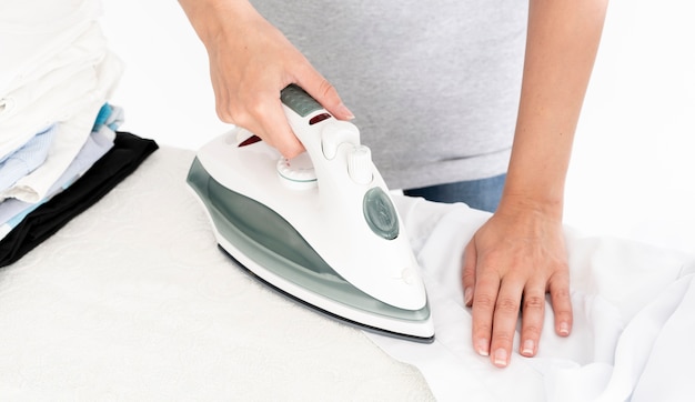 Unrecognisable lady ironing clothes