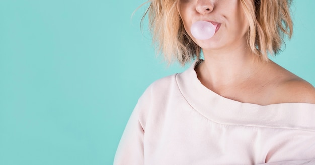 Free photo unrecognisable model blowing bubble gum