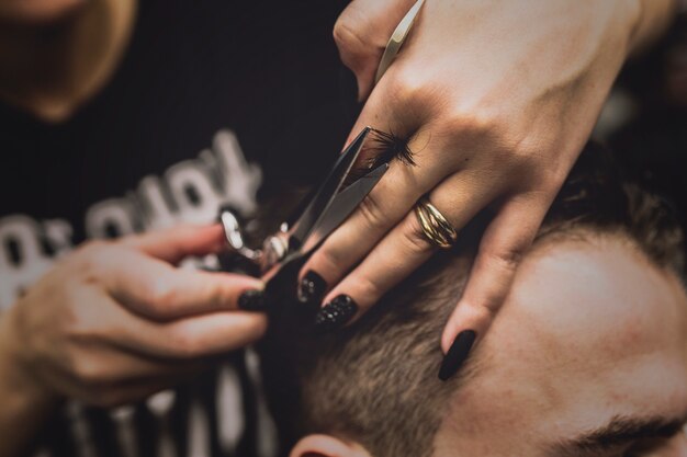 Unrecognizable barber cutting hair of man