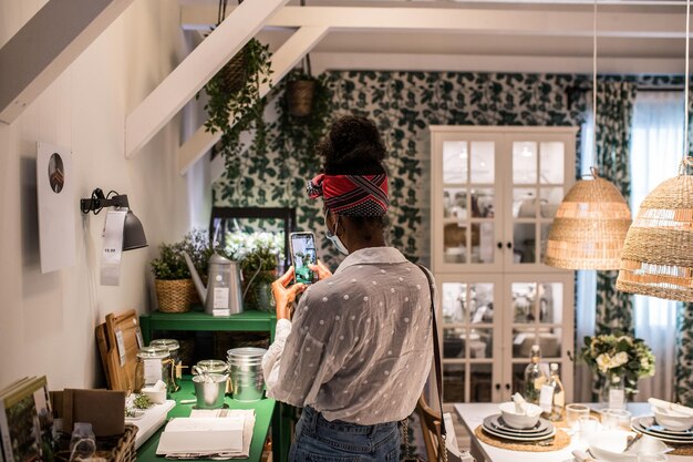 Unrecognizable black buyer taking furniture photo in mall during coronavirus pandemic