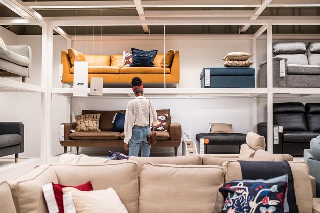 Unrecognizable black female customer choosing furniture in shopping center