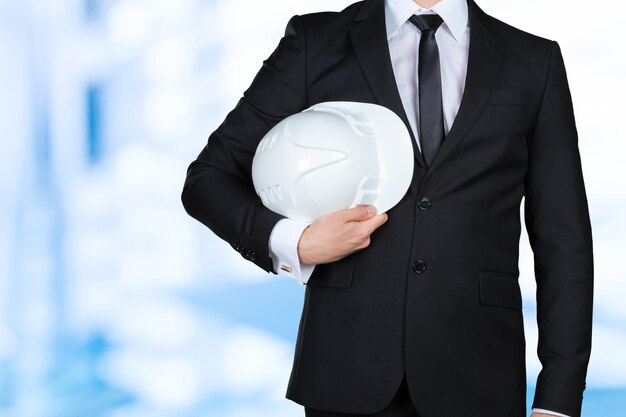 Unrecognizable businessman holding white hardhat