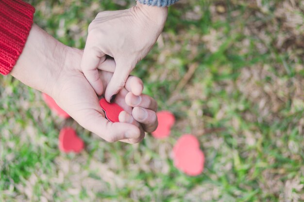 Unrecognizable couple holding paper hearts