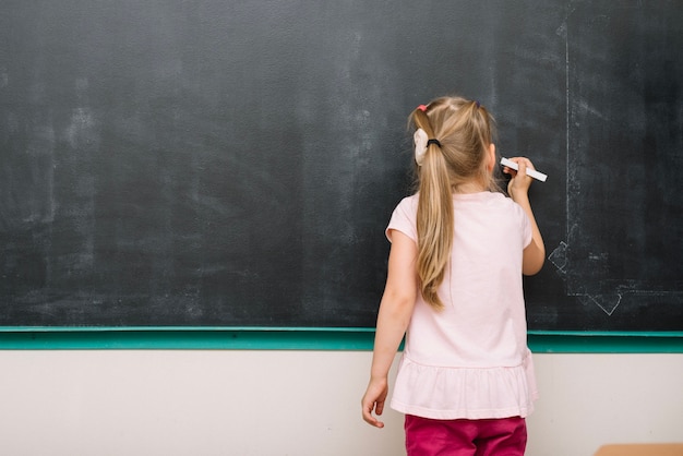 Unrecognizable girl drawing with chalk