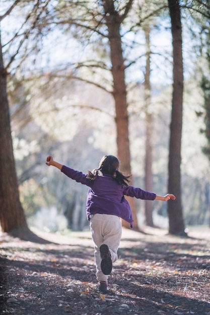 Unrecognizable girl running in forest