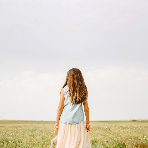 Нераспознаваемая девушка, стоящая в поле