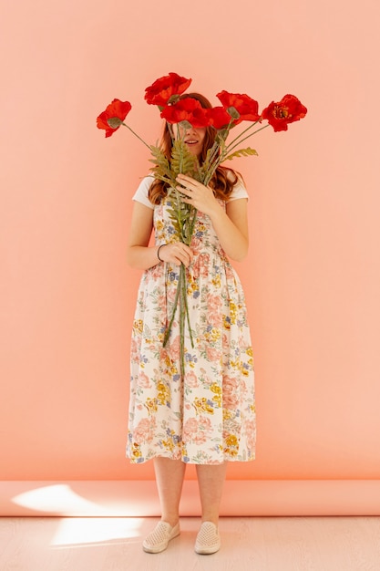 Free photo unrecognizable lady holding flower full shot