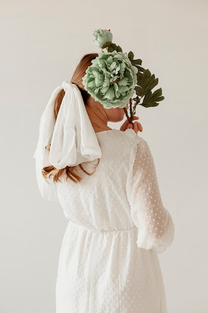 Free photo unrecognizable lady holding flowers back shot