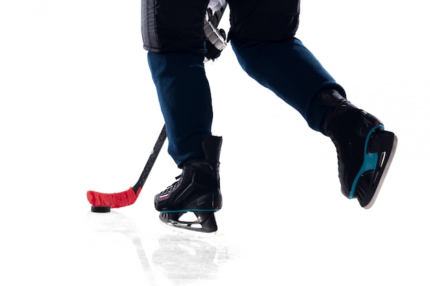 Unrecognizable male hockey player with the stick on ice court