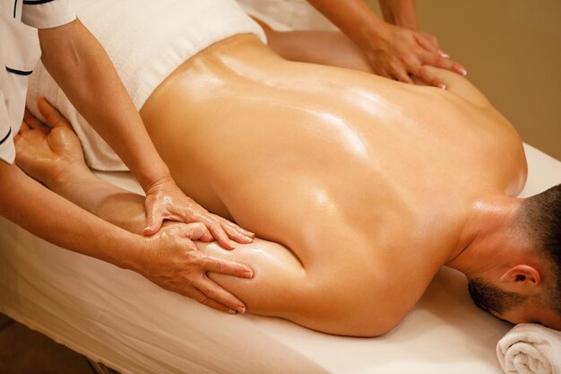 Unrecognizable man enjoying in relaxing massage at health spa