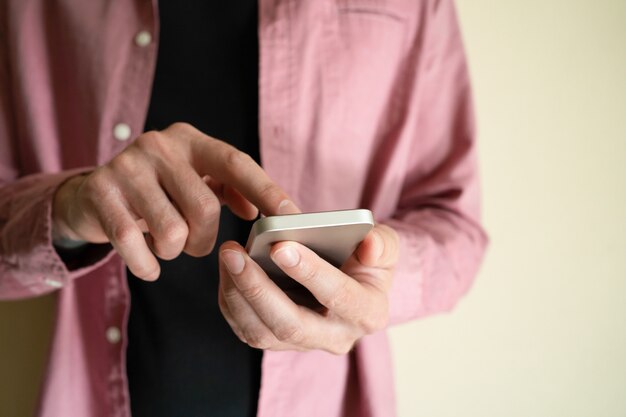 Unrecognizable man holding smartphone and touching screen