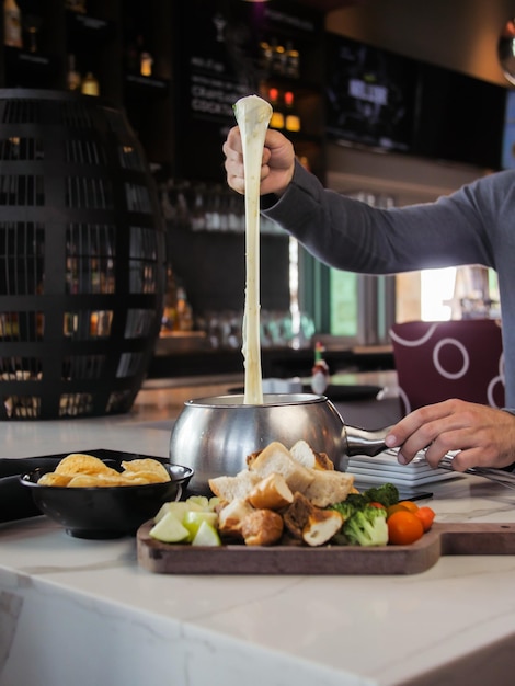 Free photo unrecognizable man melting cheese in a restaurant