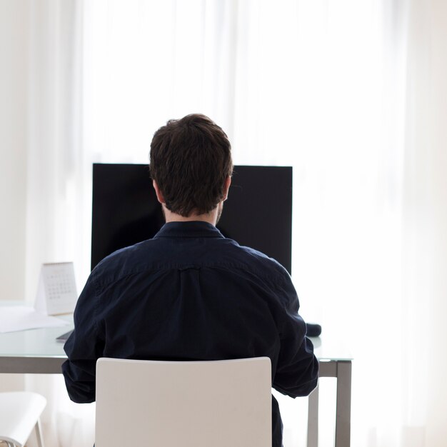 Unrecognizable man using computer in office