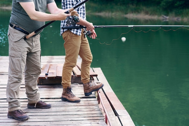 Free photo unrecognizable men with fishing rod fishing