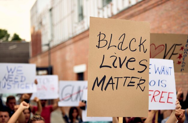 인종차별과 경찰의 만행에 반대하는 시위 중 Black Lives Matter가 적힌 플래카드를 들고 있는 알아볼 수 없는 사람