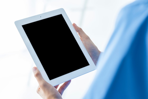 Unrecognizable surgeon holding tablet with empty screen