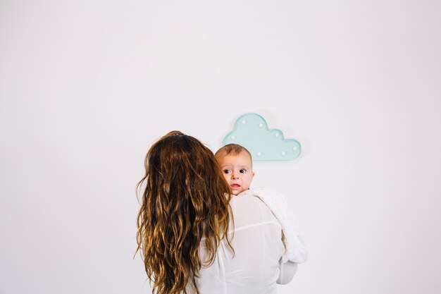 Unrecognizable woman embracing adorable baby