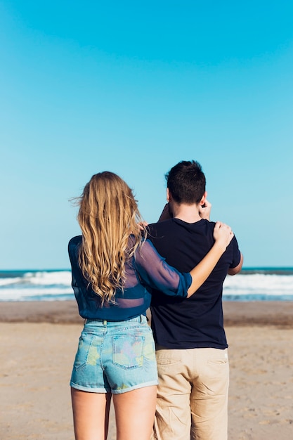 Unrecognizable woman embracing man with camera