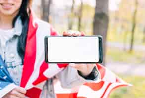 Free photo unrecognizable woman holding american flag and mobile phone