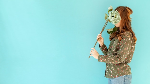 Unrecognizable woman holding flower side view