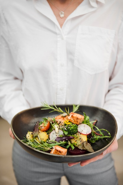 Unrecognizable woman holding salmon meal