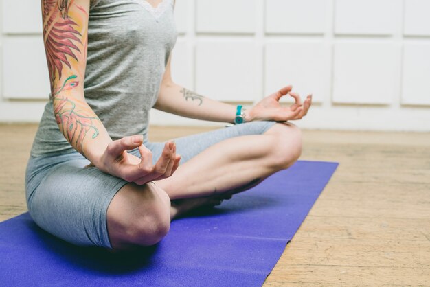 Unrecognizable woman meditating at home