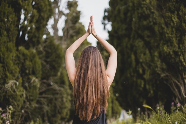 Unrecognizable woman meditating in nature