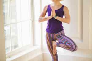 Free photo unrecognizable woman meditating at window