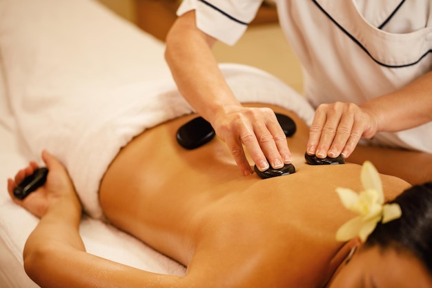 Unrecognizable woman relaxing during lastone therapy at wellness spa