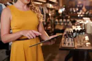 Free photo unrecognizable woman using tablet in department store