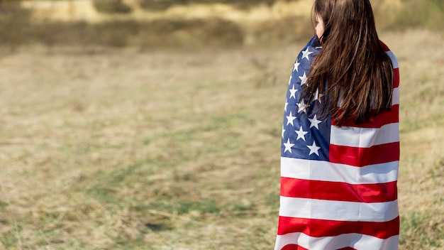 認識できない女性の独立記念日にアメリカ国旗を包む