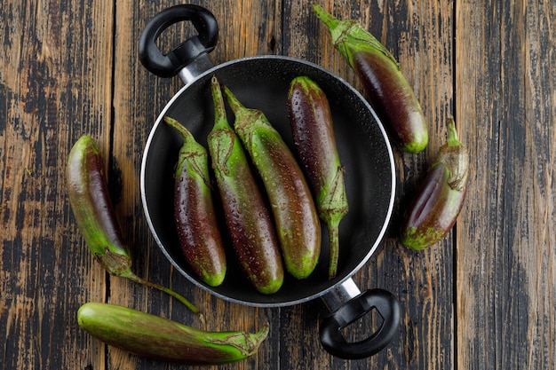 Free photo unripe eggplants in a pan on a wooden.