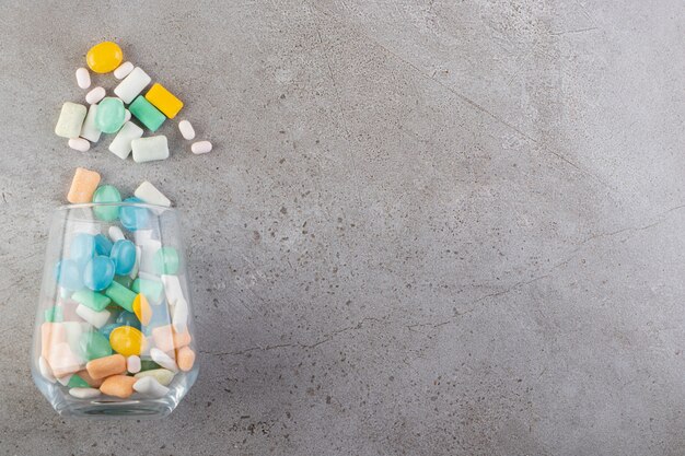 Unwrapped sugar free chewing gum sticks placed in a glass cup.