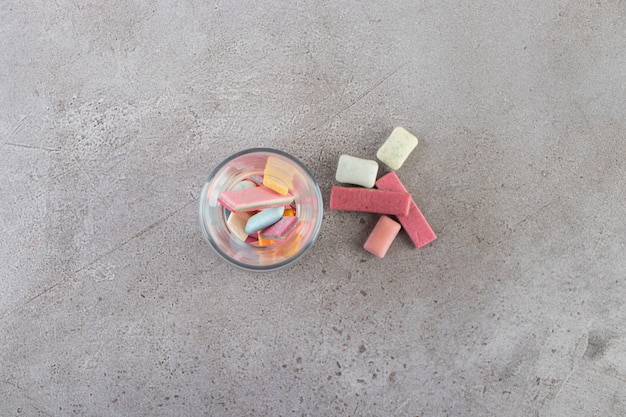 Unwrapped sugar free chewing gum sticks placed in glass.