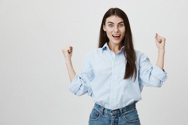 Upbeat confident woman raise fists in victory, triumphing