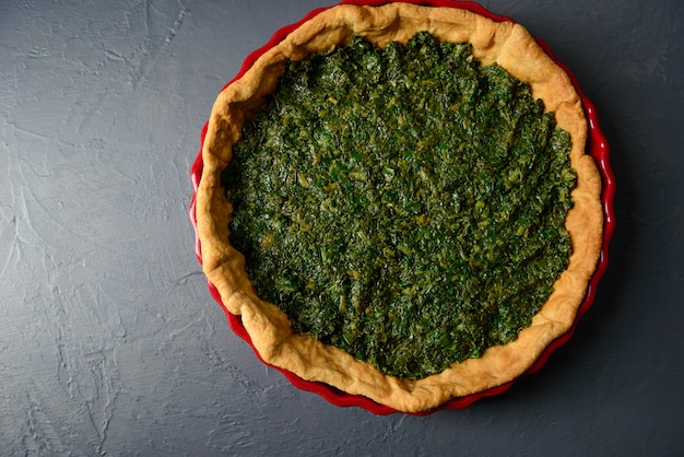 Upper view of baked tart dough with spinach