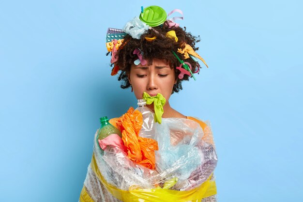 Upset Afro woman does volunteer work, wrapped in cellophane