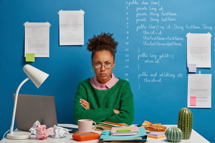 Free Photo upset afro woman looks with gloomy expression, poses in coworking space, creats own startup based on innovative forecasting, uses notepad to write down information