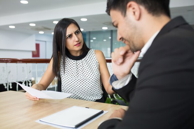 Upset business lady dressing down employee for mistakes